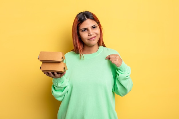 Hispanische Frau, die arrogant, erfolgreich, positiv und stolz aussieht. Burger-Konzept zum Mitnehmen