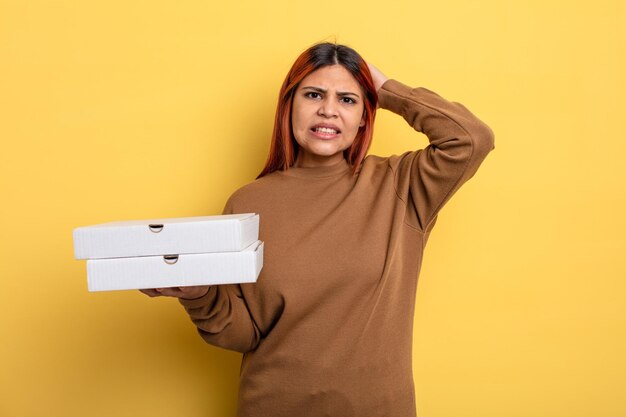 hispanische frau, die sich gestresst, ängstlich oder ängstlich fühlt, mit den händen auf dem kopf. Pizza-Konzept zum Mitnehmen