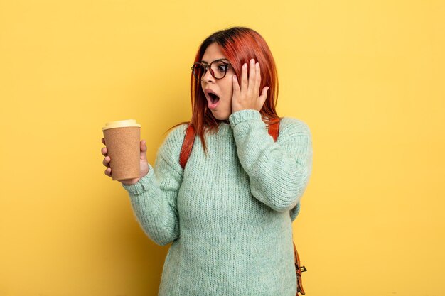 hispanische frau, die sich glücklich, aufgeregt und überrascht fühlt. student mit einem kaffeekonzept