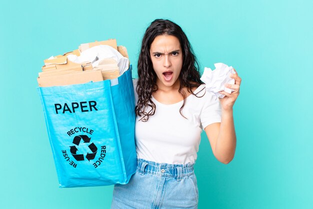 Hispanische hübsche Frau, die eine Recyclingpapiertüte hält