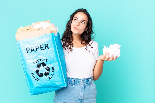 Hispanische hübsche Frau, die eine Recyclingpapiertüte hält