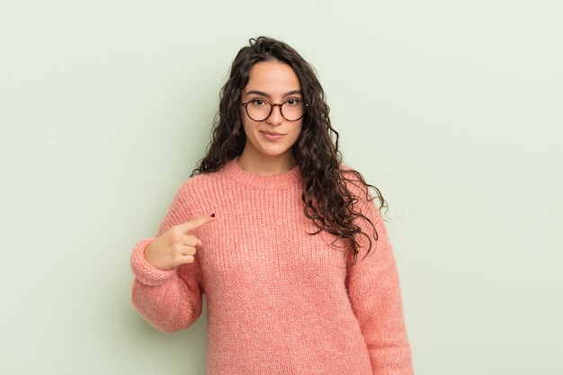 Hispanische hübsche Frau, die stolz, selbstbewusst und glücklich lächelt und auf sich selbst zeigt oder das Zeichen Nummer eins macht