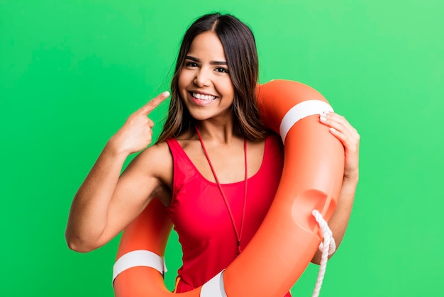 Hispanische hübsche junge erwachsene Frau mit Badeanzug und Rettungsschwimmer-Konzept