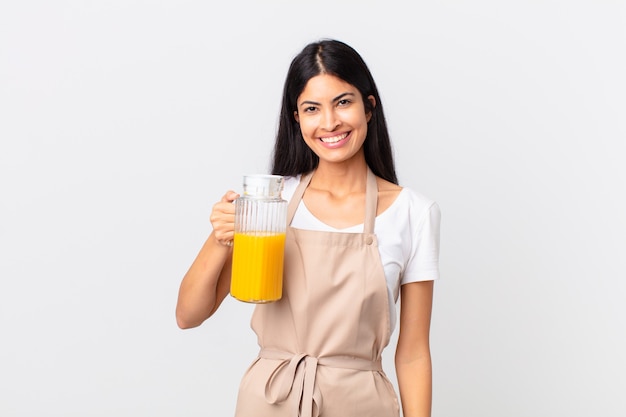 Hispanische hübsche Kochfrau. Orangensaft und Frühstückskonzept