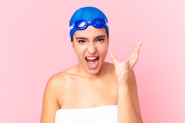 Foto hispanische hübsche schwimmerin, die wütend, genervt und frustriert mit schutzbrillen aussieht