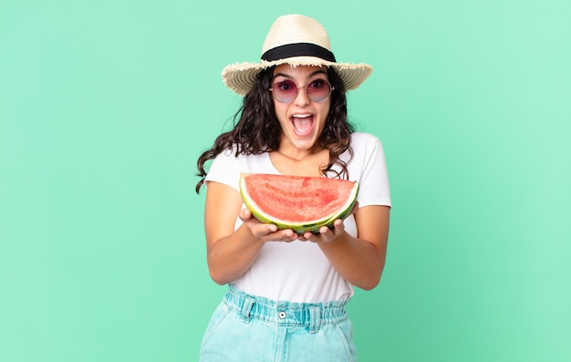 Hispanische hübsche Touristenfrau, die eine Wassermelone hält