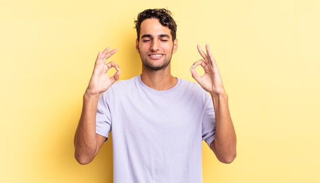 Hispanischer gutaussehender Mann, der konzentriert und meditierend aussieht