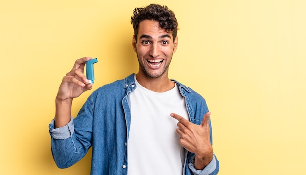 Hispanischer gutaussehender Mann, der sich glücklich fühlt und mit einem aufgeregten auf sich selbst zeigt. Asthma-Konzept