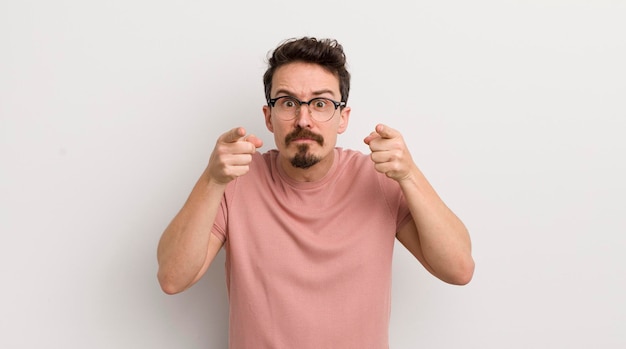 Foto hispanischer junger mann, der mit beiden fingern und wütendem gesichtsausdruck nach vorne auf die kamera zeigt und ihnen sagt, dass sie ihre pflicht tun sollen