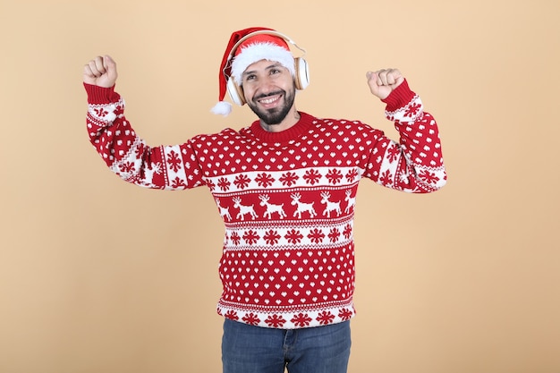 hispanischer Latino-Mann, zu Weihnachten mit Weihnachtsmütze lächelnd gelben Hintergrund