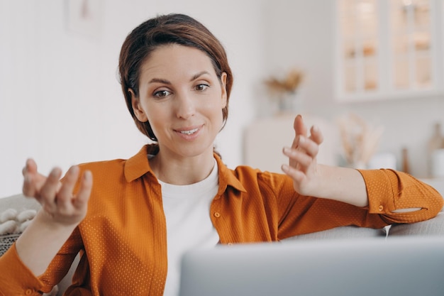 Foto hispanischer weiblicher chat per videoanruf, der sich mit dem laptop zu hause unterhalten kann online-kommunikation