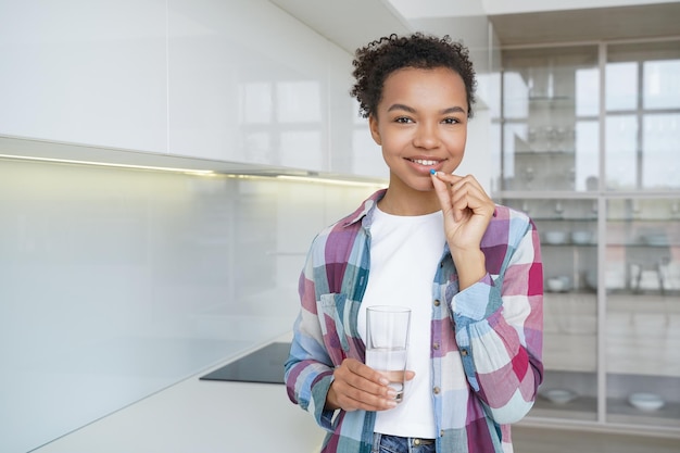 Hispanisches Teenager-Mädchen nimmt Vitamine oder Schmerzmittel ein Krankheitsprävention Coronavirus Genesung