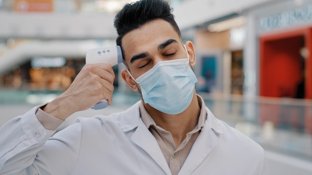 Hispano étnico indio doctor hombre terapeuta trabajador médico masculino en máscara cansado agotado frustrado