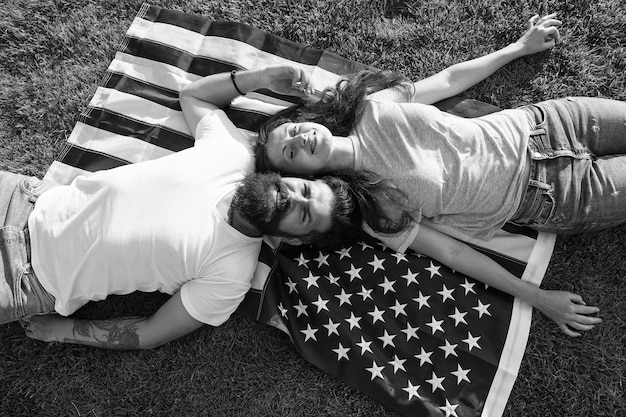 Historia de América Pueblo patriótico estadounidense Pareja estadounidense relajándose en la bandera de EE. UU. Al aire libre Día de la Independencia Fiesta nacional Hipster barbudo y chica enamorada 4 de julio Tradición estadounidense