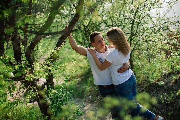 historia de amor al aire libre. Amantes caminando en el parque de primavera. elegante pareja de enamorados abrazándose en un paseo en primavera. pareja emocional caminando al aire libre