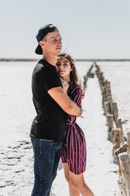 Historia de amor en el desierto, feliz pareja joven, los jóvenes están caminando y tomados de la mano, vacaciones de verano para una pareja joven