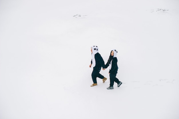 Historia de amor de invierno, una hermosa joven pareja en trajes de panda