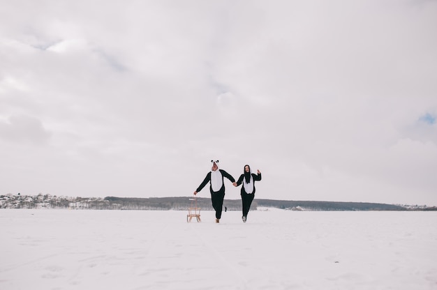 Historia de amor de invierno, una hermosa joven pareja en trajes de panda