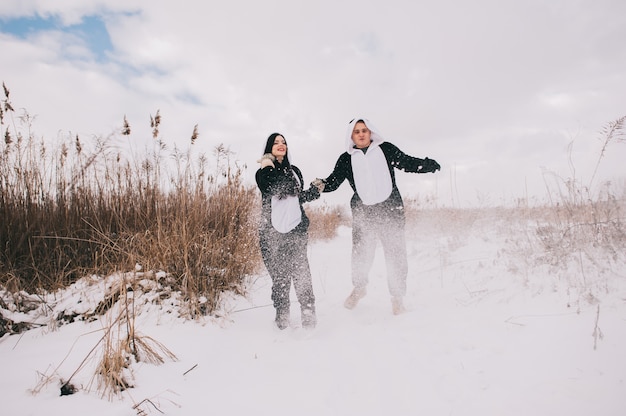 Historia de amor de invierno, una hermosa joven pareja en trajes de panda