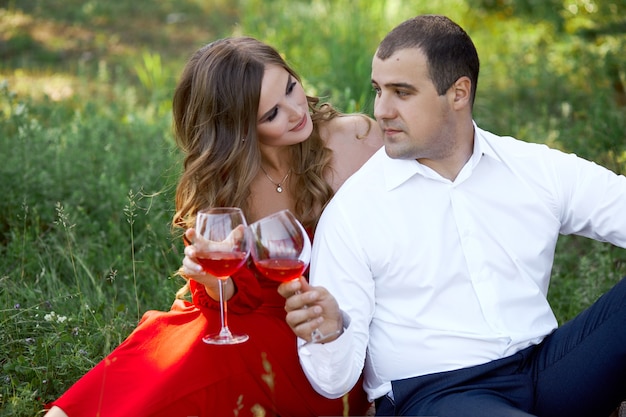 Historia de amor de una pareja amorosa de hombres y mujeres en la primavera en la naturaleza en el bosque. Abrazos de pareja, picnic en el parque