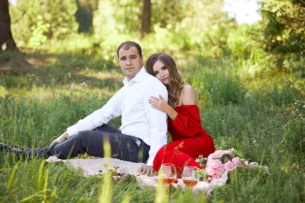 Historia de amor de una pareja amorosa de hombres y mujeres en la primavera en la naturaleza en el bosque. Abrazos de pareja, picnic en el parque