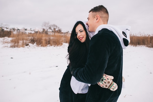 História de amor de inverno, um lindo casal jovem em ternos de panda