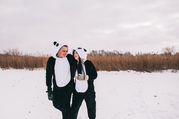 História de amor de inverno, um lindo casal jovem em ternos de panda