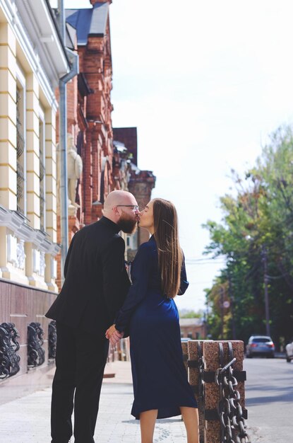 História de amor urbano. jovem barbudo de terno azul. Mulher atraente no vestido. Casal andando. Encontro