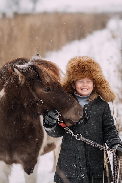 História de inverno de amizade entre uma menina e um pônei 3097