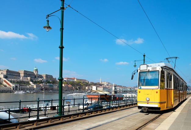 Historische Straßenbahn fährt am Flussufer in Budapest