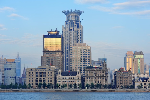 Historische und städtische Gebäude Shanghais über Huangpu-Fluss morgens mit blauem Himmel.