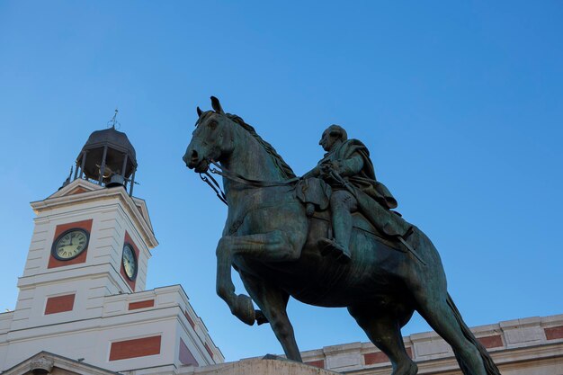 Foto historisches gebäude der puerta del sol in madrid mit statue