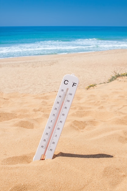Hitzezeit, um in den Urlaub an den Strand zu kommen. Thermometer am Strand.
