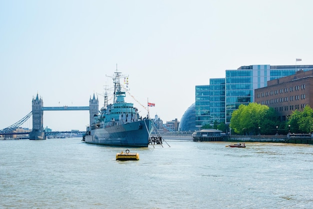 HMS Belfast Ship y Tower Bridge en la ciudad de Londres en el Reino Unido, Inglaterra. Vista sobre el acorazado de la Marina Real en el río Támesis y el cielo azul. Paisaje urbano en Gran Bretaña, Europa. Icono famoso de guerra.