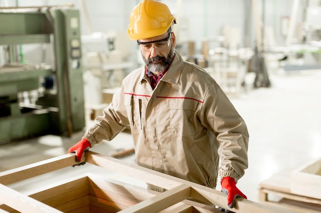 Hndsome trabajador de mediana edad que trabaja en la fábrica de muebles