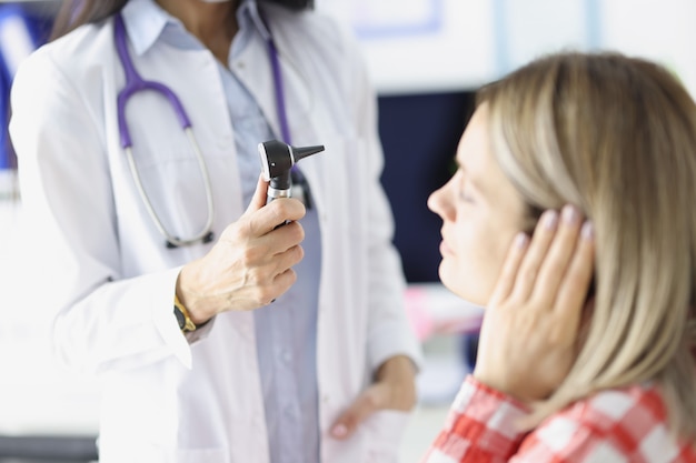 HNO-Arzt untersucht ein Frauenohr mit Otoskop-Hörbehinderung im Erwachsenenkonzept