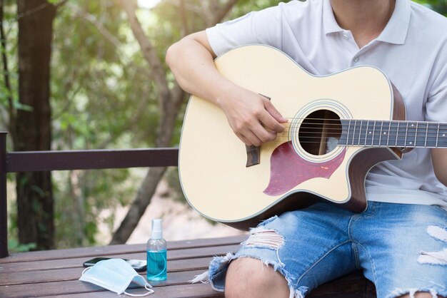 Hobbies durante a quarentena Guitarrista no jardim em casa Copyspace