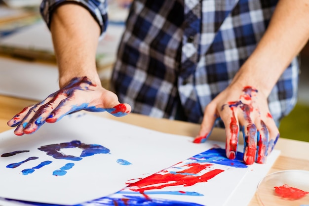 Hobby de arte ocupación profesional Manos de hombre primer plano Impresión de pintura en papel blanco Proyecto creativo sobre la individualidad humana