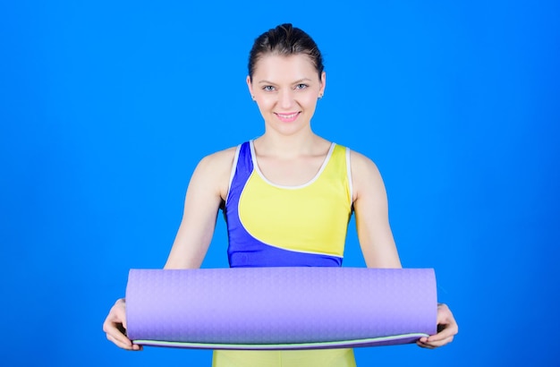 Hobby y deporte de yoga. Practicando yoga todos los días. Chica atleta slim fit mantenga estera de fitness. Fitness y estiramiento. Estiramiento de los músculos. Entrenadora de yoga para deportistas. Calentamiento antes del entrenamiento. Concepto de clase de yoga.