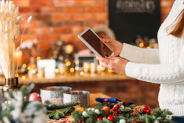 Hobby der Floristin Schnappschuss einer Dame, die ein Tablet verwendet, um einen professionellen Blog im Workshop aufzuzeichnen