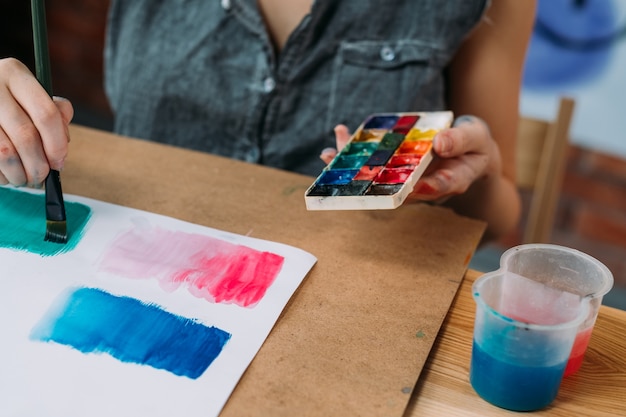 Foto hobby e criatividade. foto recortada de uma jovem artista pintando arte abstrata com aquarela.
