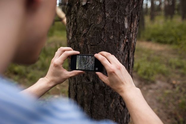 hobby de fotografía de naturaleza. hombre tomando fotos con celular en el bosque