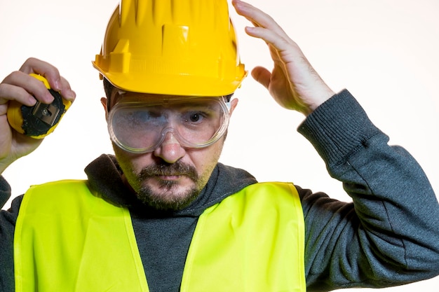 hobby un hombre que quiere hacer un trabajo sin conocimiento, trabajo sin experiencia. Hágalo usted mismo, hombre vestido con casco de constructor amarillo con gafas protectoras listo para comenzar el trabajo de construcción