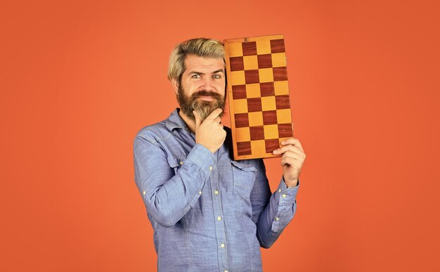 Hobby und Freizeit Intellektuelle Spiele Schachstunde Lehrerschachwettbewerb Schachfiguren Spielstrategiekonzept Brettspiel Man spielt Schach Intelligenter bärtiger Hipster Kognitive Fähigkeiten