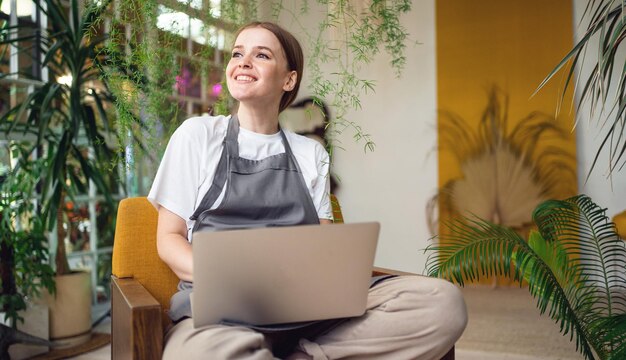 Foto hobbyfloristik eine frau arbeitet in einer werkstatt und erhält mit einem laptop eine bestellung von einem kunden