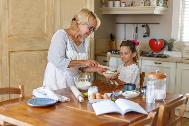 Hobbys und Freizeit. Großmutter und Enkelin bereiten gemeinsam in der Küche zu. Bindungsbeziehung und die Beteiligung zwischen den erzeugten