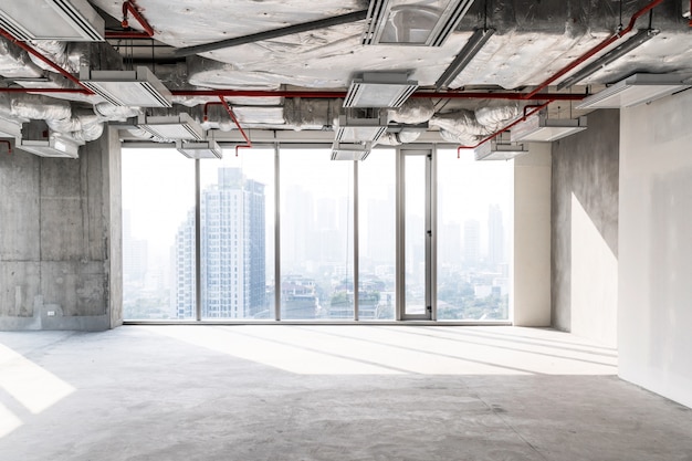 Hochhausbüro im Bau mit offener Decke, um Struktur und Systemarbeiten zu sehen, Glasfenster für die Luftaufnahme von Gebäuden in der Stadt. Leerer Platz für Entwicklerinvestitionen.