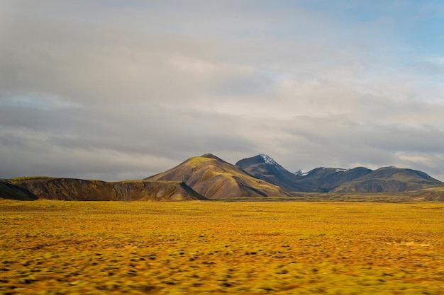 Hochland in Island. Berge mit grünem Moos am bewölkten Himmel. Wildnis, nördliche Natur. Reisen, Entdecken, Abenteuer, Fernweh-Konzept