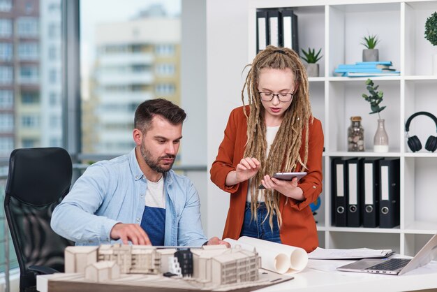 Hochqualifizierte, fleißige, kreative Designerinnen und Designer, die mit dem Modell zukünftiger Gebäude arbeiten