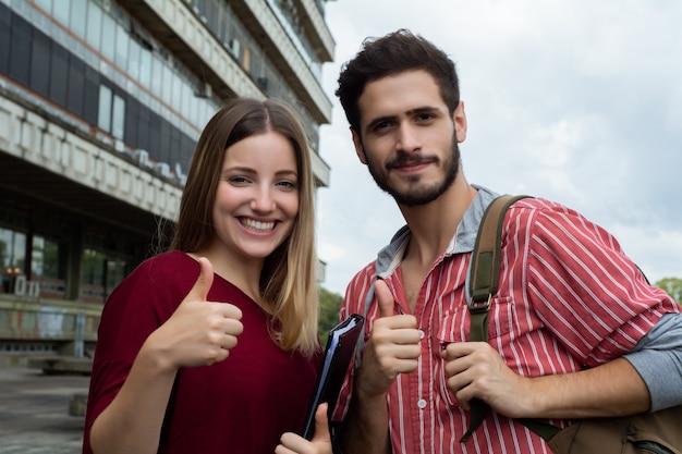 Hochschulstudenten, die sich Daumen zeigen